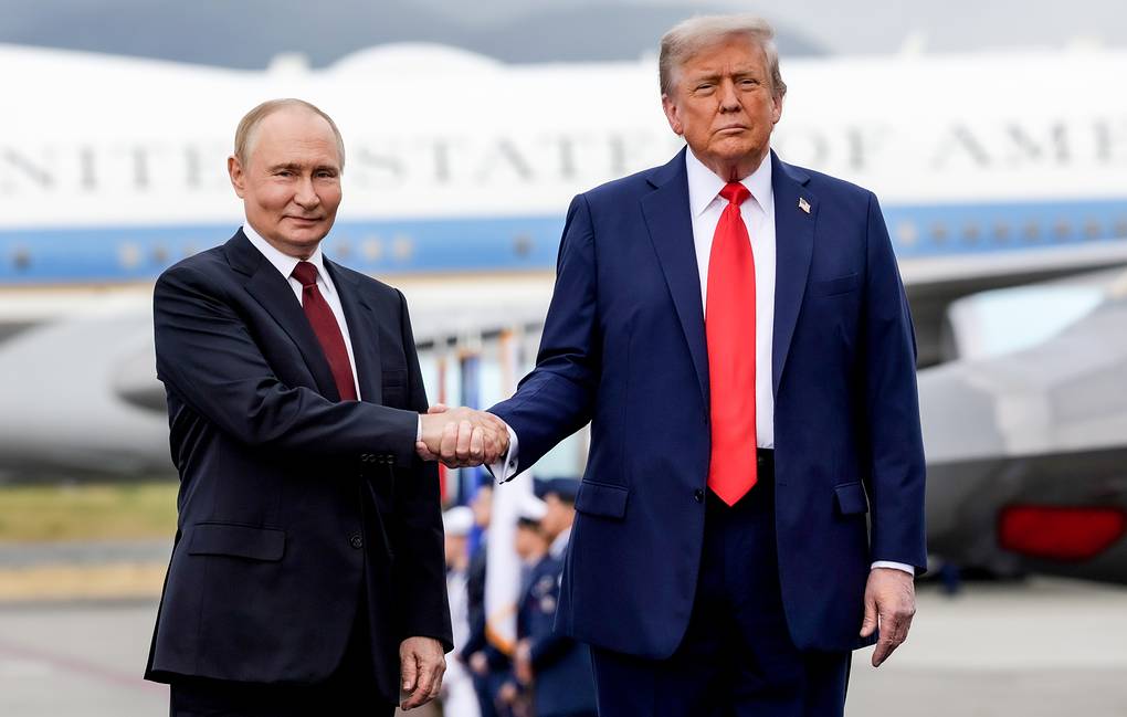 US President Donald Trump and Ukrainian President Volodymyr Zelenskyy shaking hands, with news of the Trump-Putin summit in the background